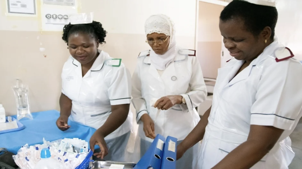 Nurses working in a hospital room.