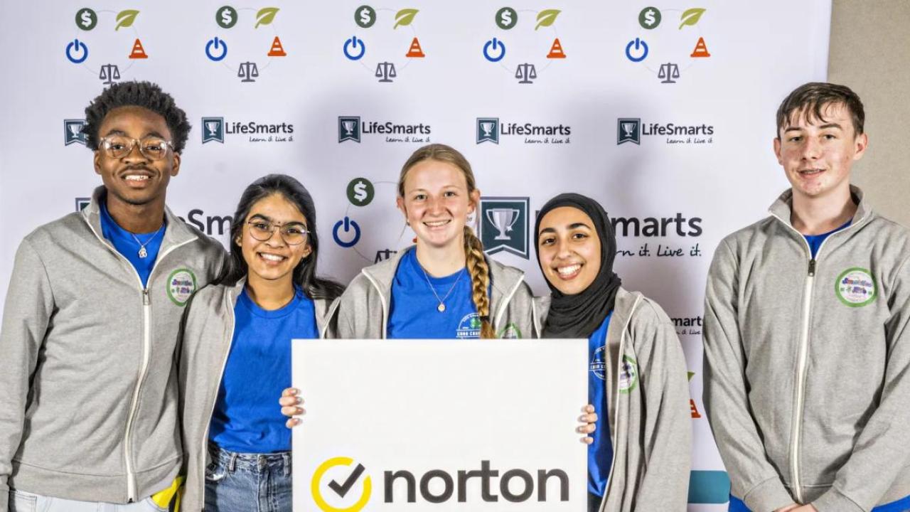 A team of five students holding a Norton sign.