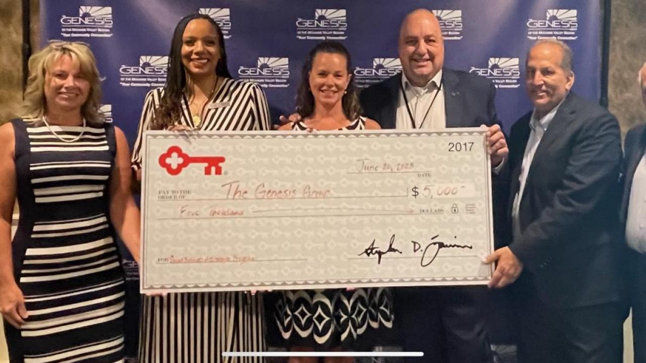 Photo of The Genesis Group receiving a grant check from KeyBank representatives.