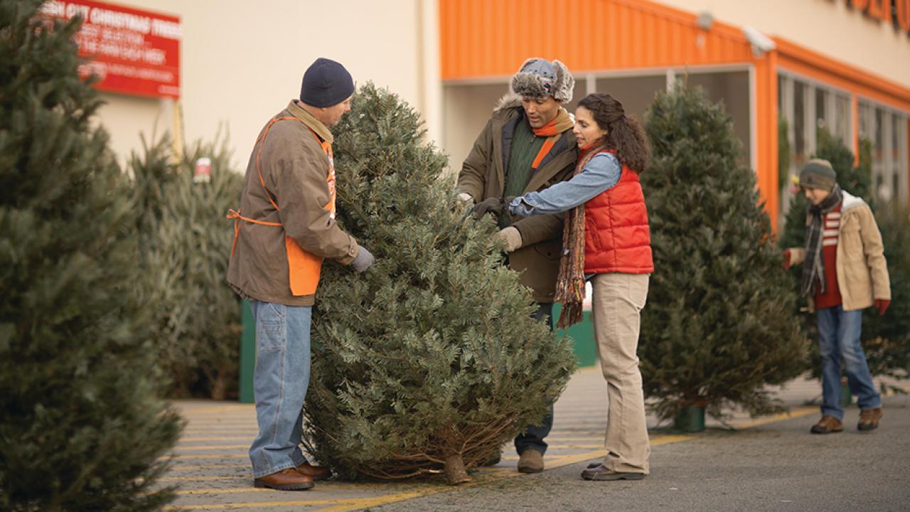 Family selecting a Christmas tree at Home Depot.