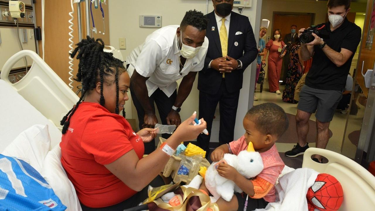 Hall of Fame football player Calvin "Megatron" Johnson Jr. delivers a My Special Aflac Duck to a patient at The Aflac Cancer and Blood Disorders Center at Children's Healthcare of Atlanta as part of Aflac's Kickoff for a Cause football game tonight in Atlanta.