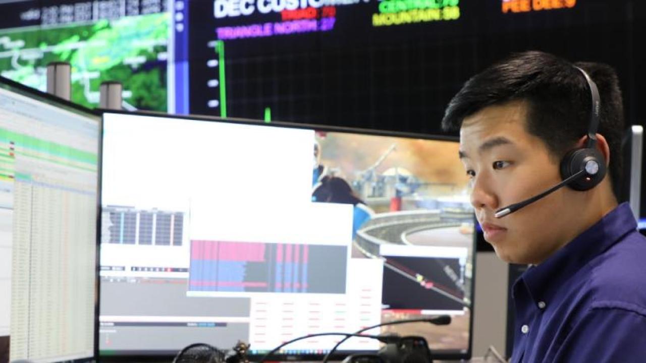 Thomas Doan wearing a headset, looking at multiple monitors.