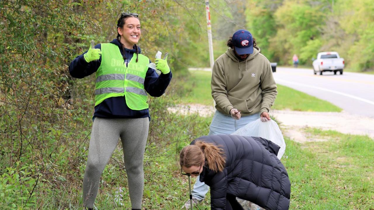 AEG employees and fans participate in the coastal clean-up initiative at Fort Morgan.