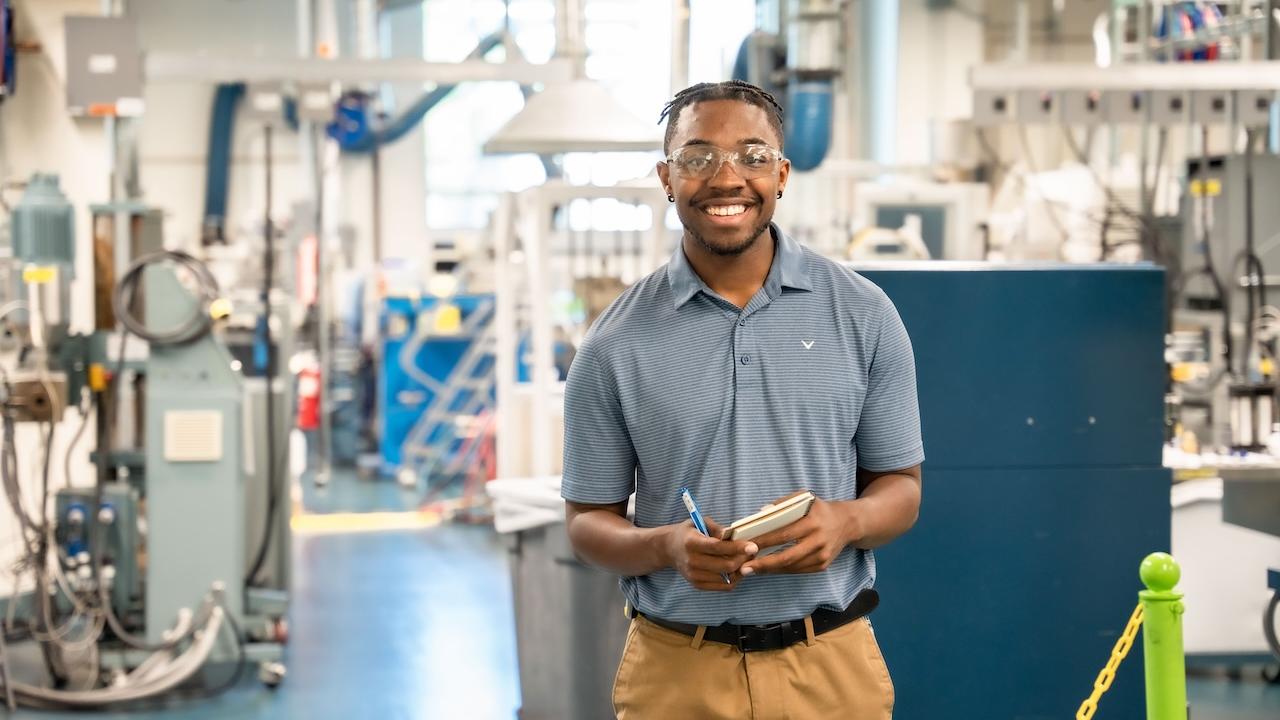 A person shown smiling in a warehouse.