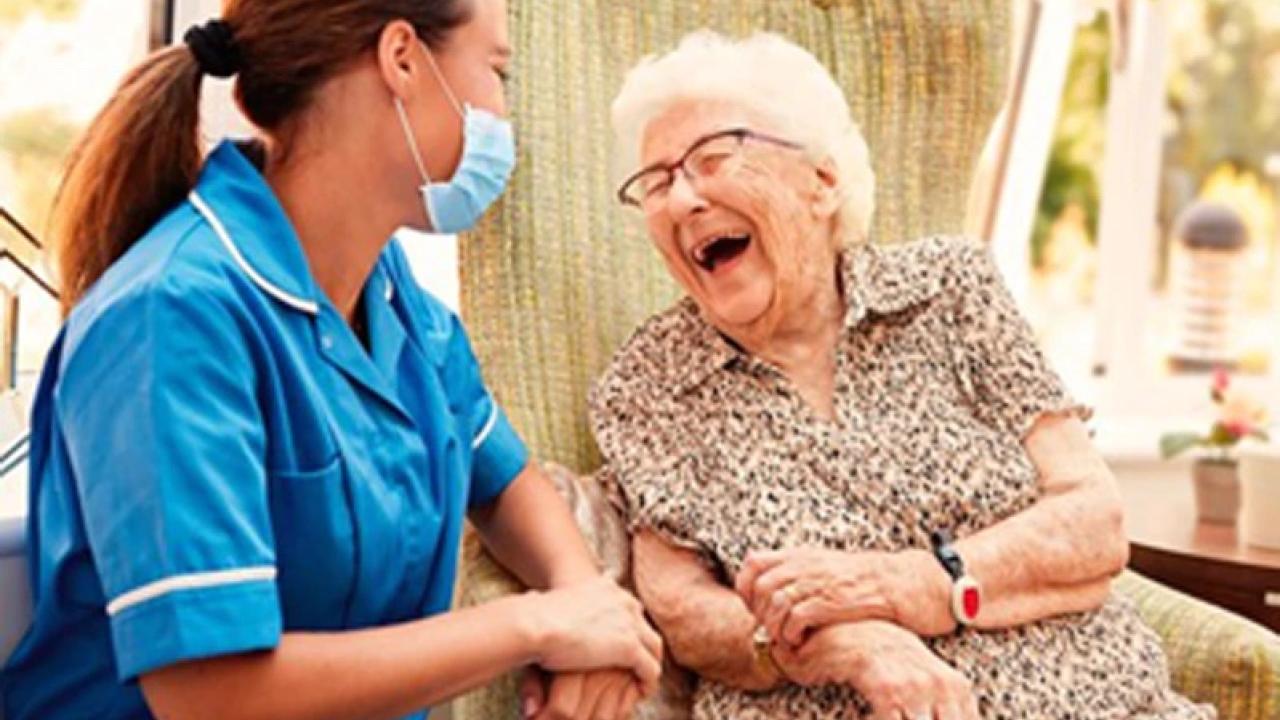 Nurse assisting an elderly woman.