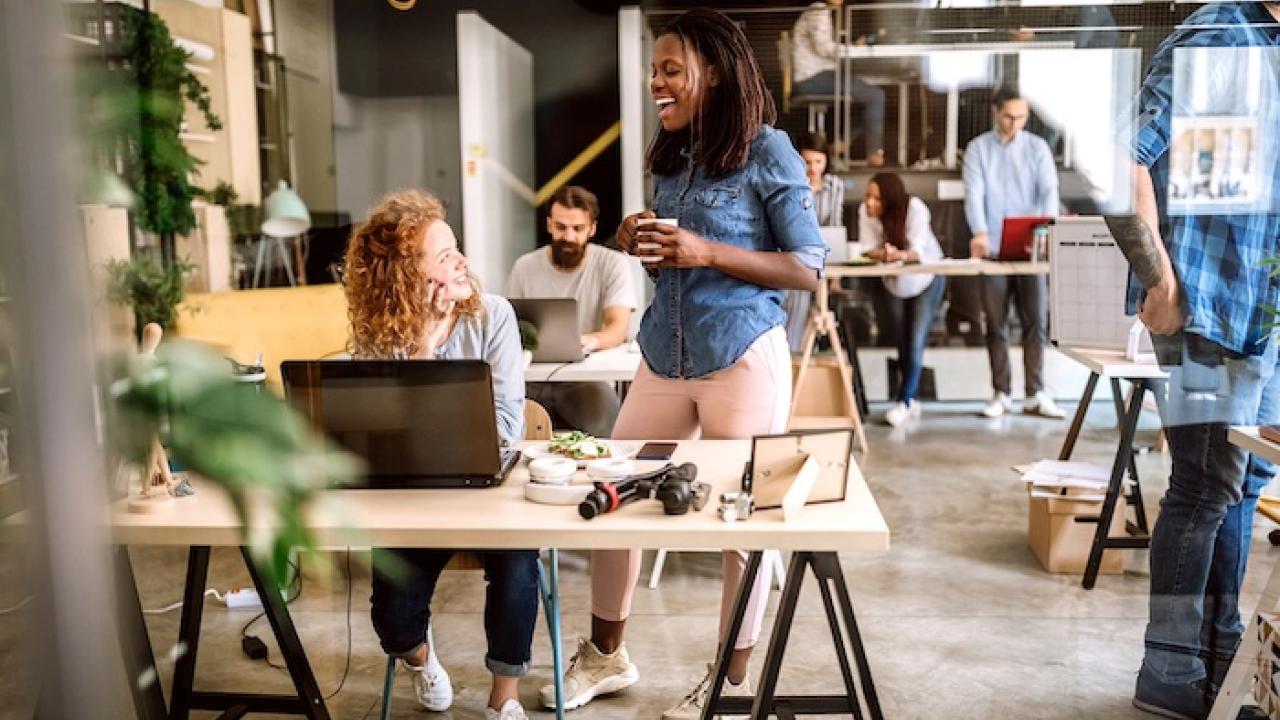 Female employees chatting in an office space.