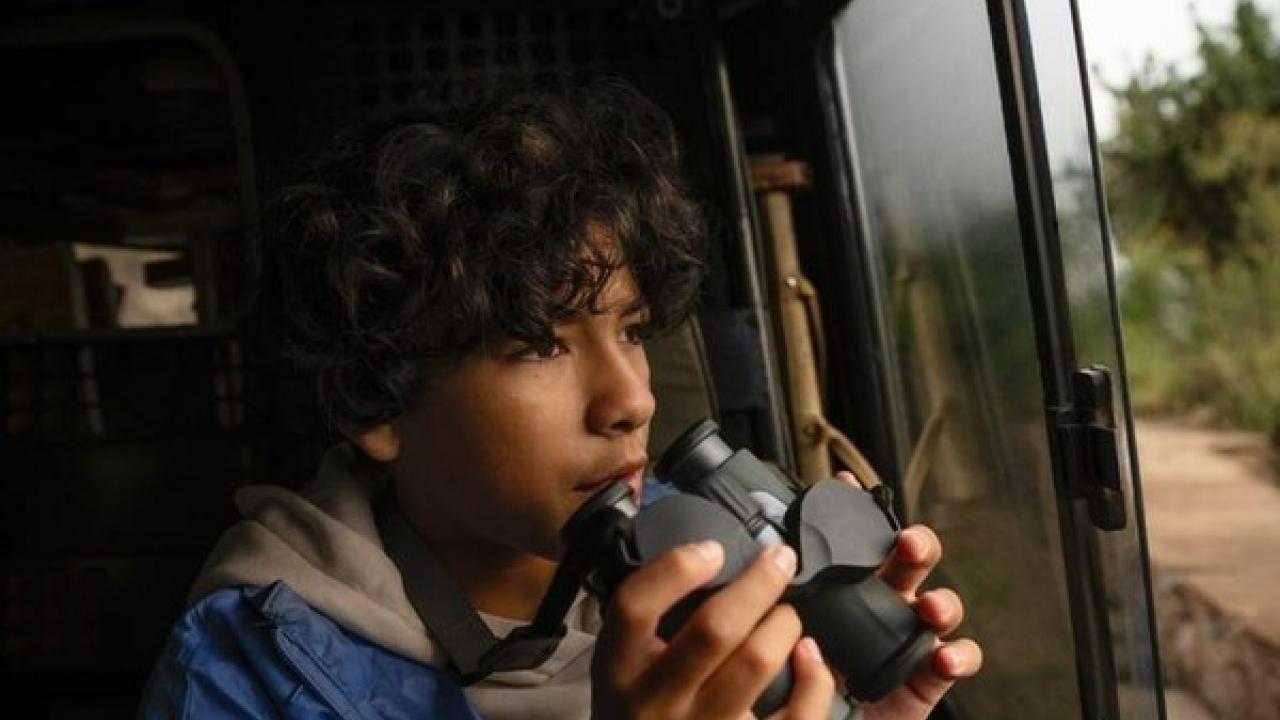 young person holding binoculars