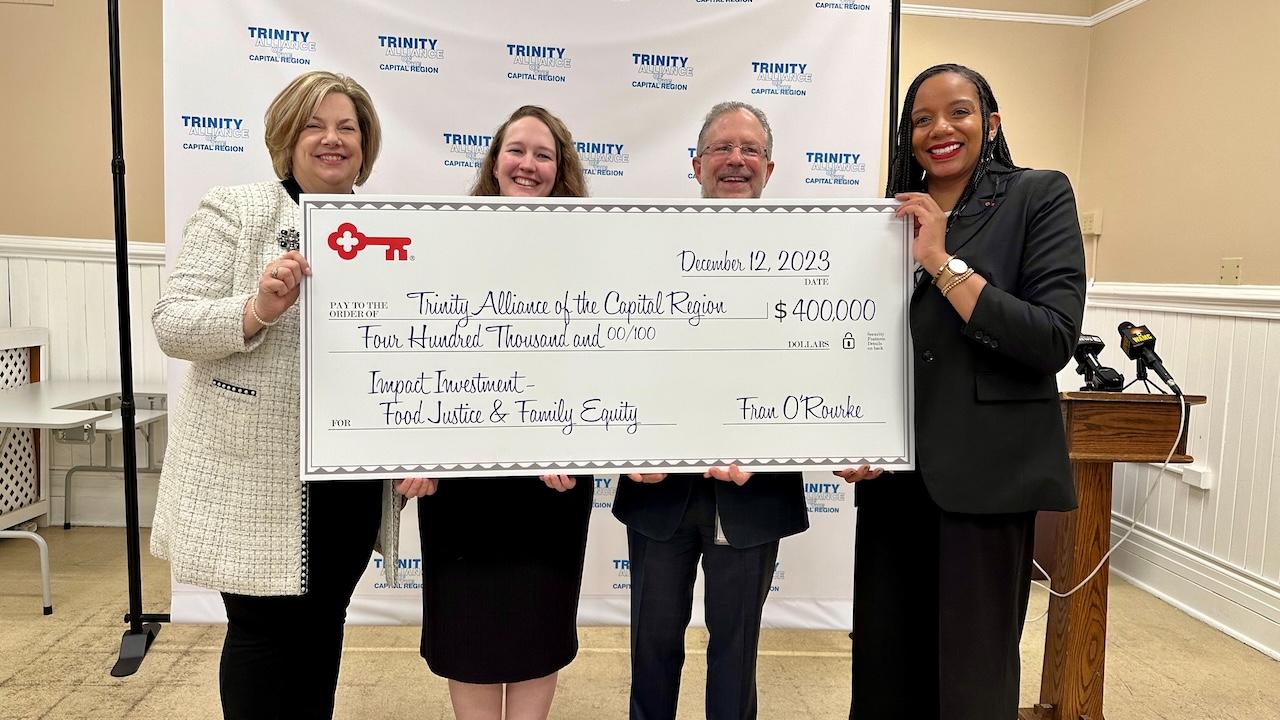 KeyBank and Trinity Alliance team members shown holding a $400,000 grant check.