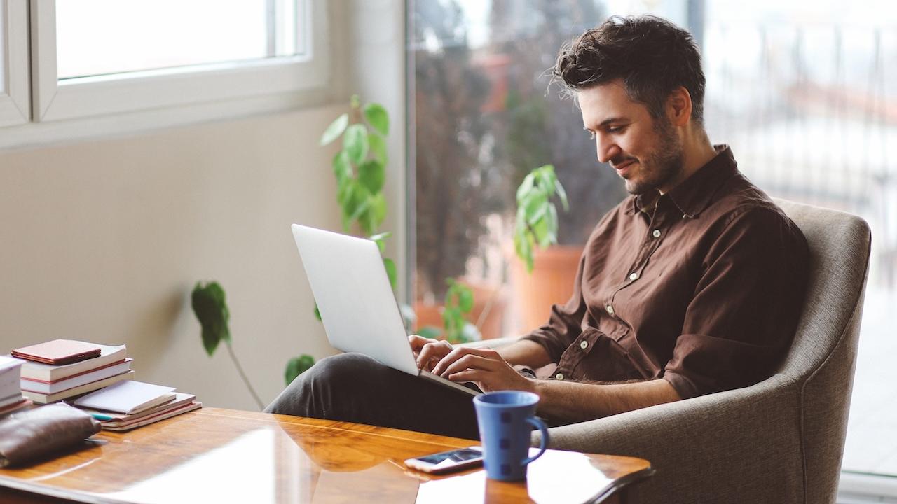 A person seated at a desk working on a laptop.