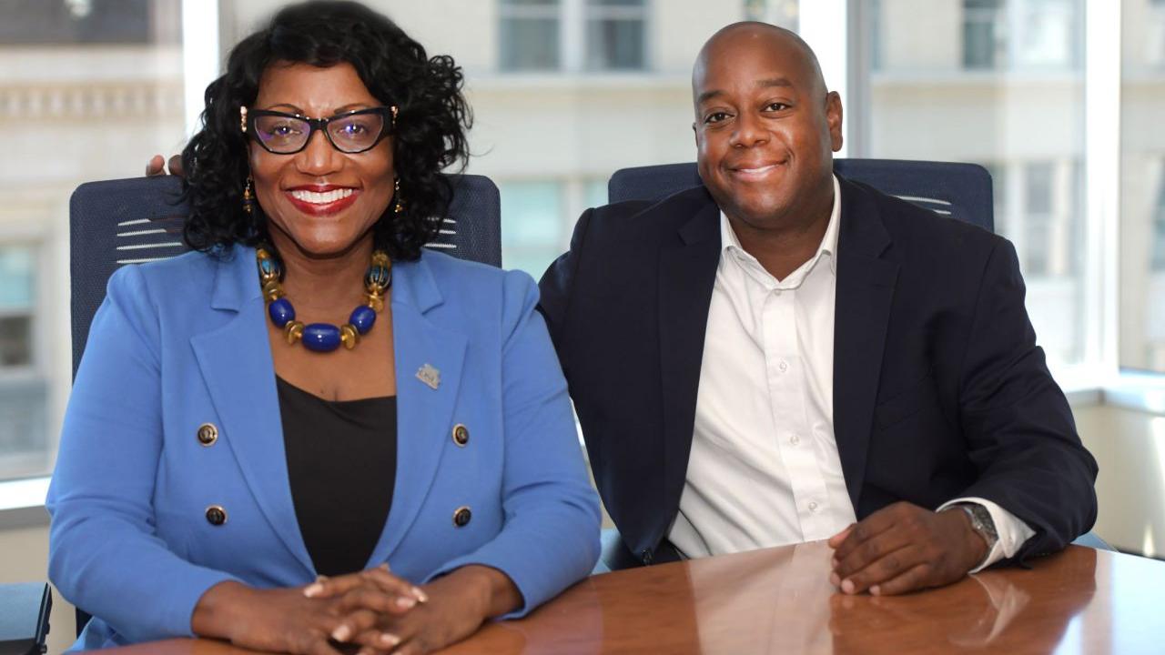 Two people sat next to each other smiling 