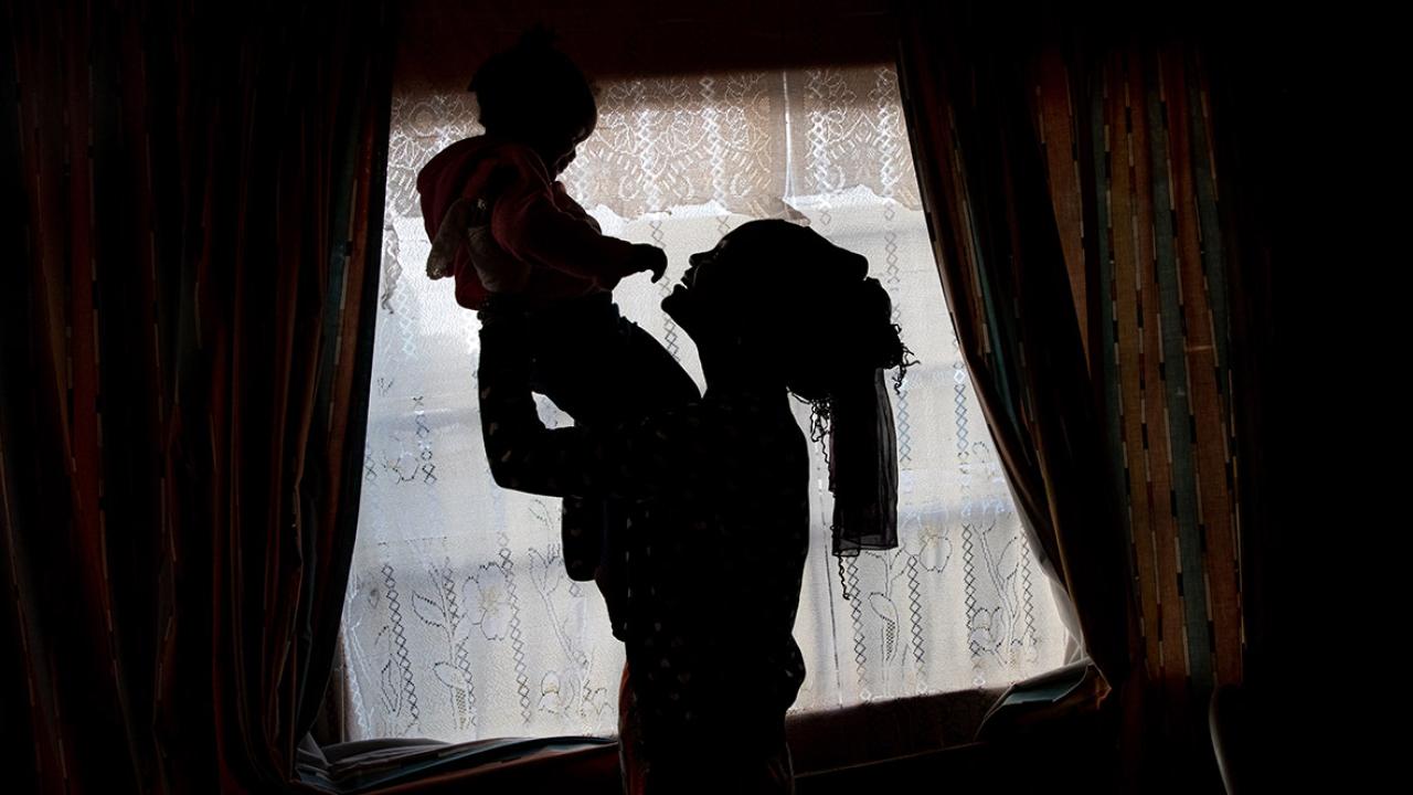 Silhouette of mother holding baby