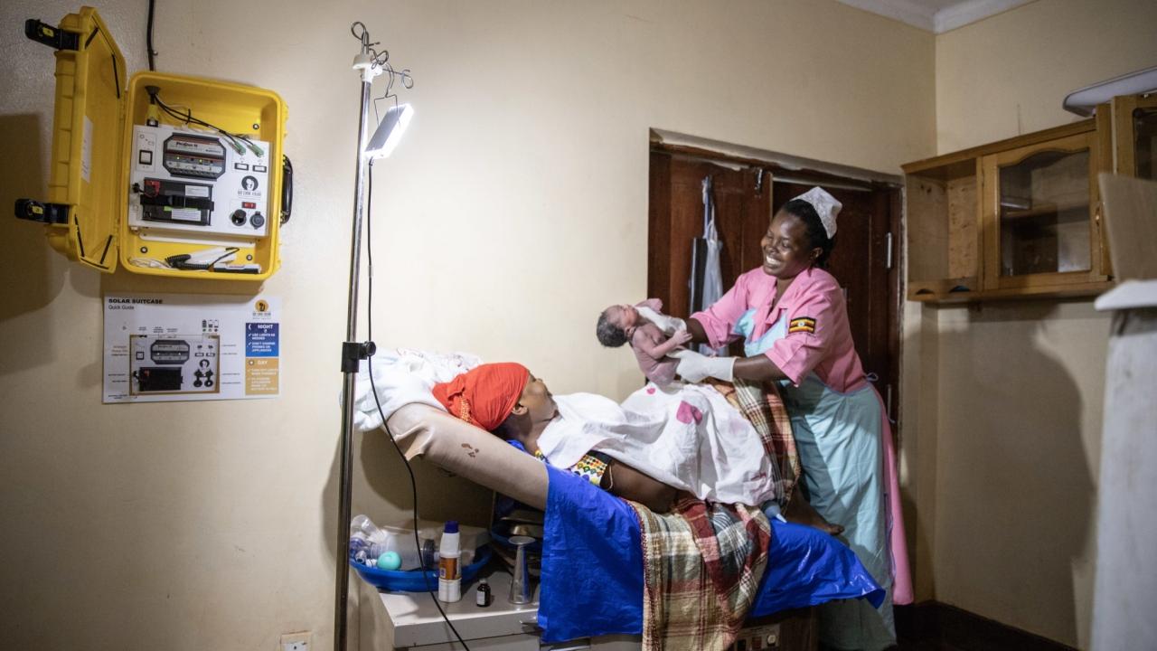 Health worker delivering baby in hospital, Uganda