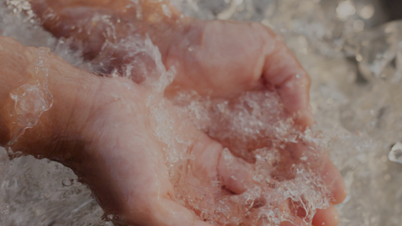 Child's hand scooping splashing water