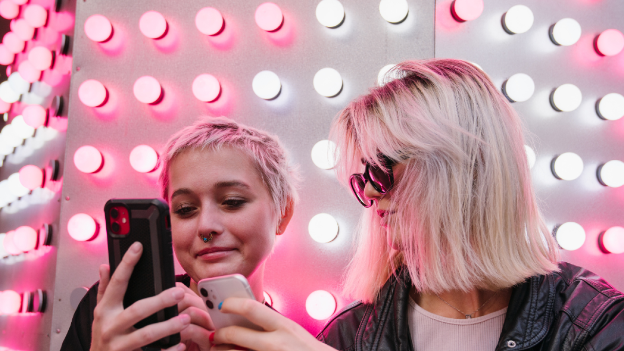 Two young women looking at cell phones
