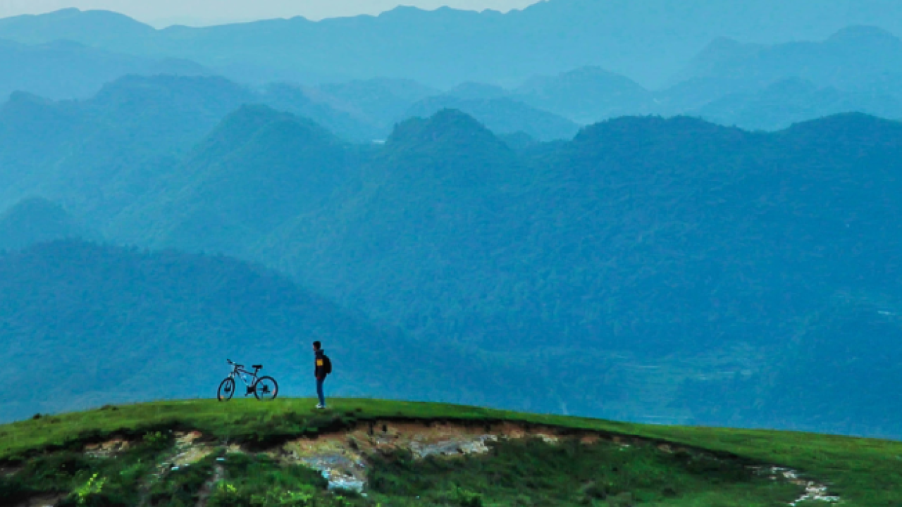 Biker ponders mountain landscape