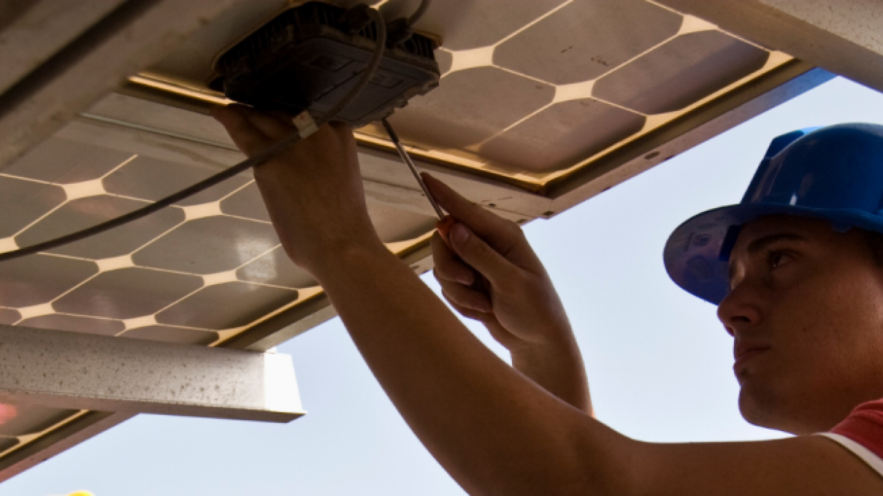 Construction worker installing solar panel