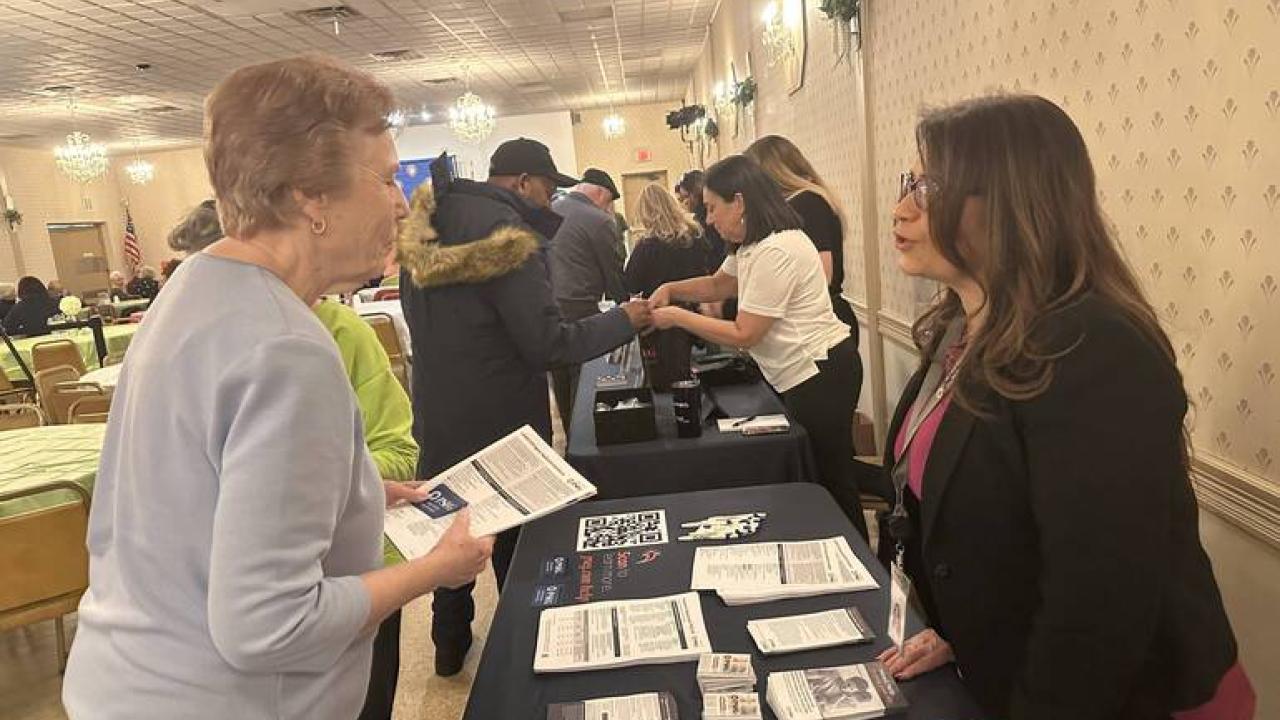 Senior speaking with someone at PSE&G's table at the event 
