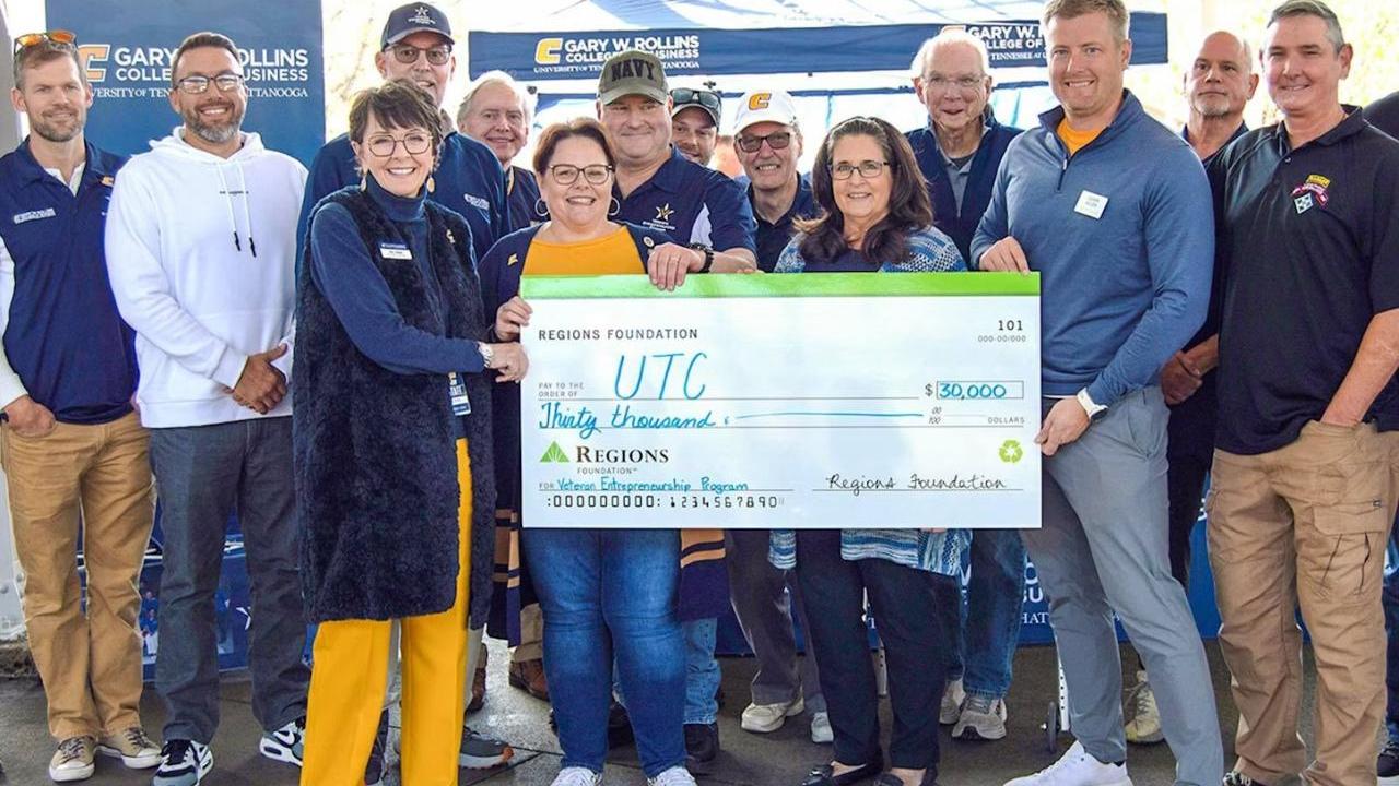 Group of people holding a cheque  