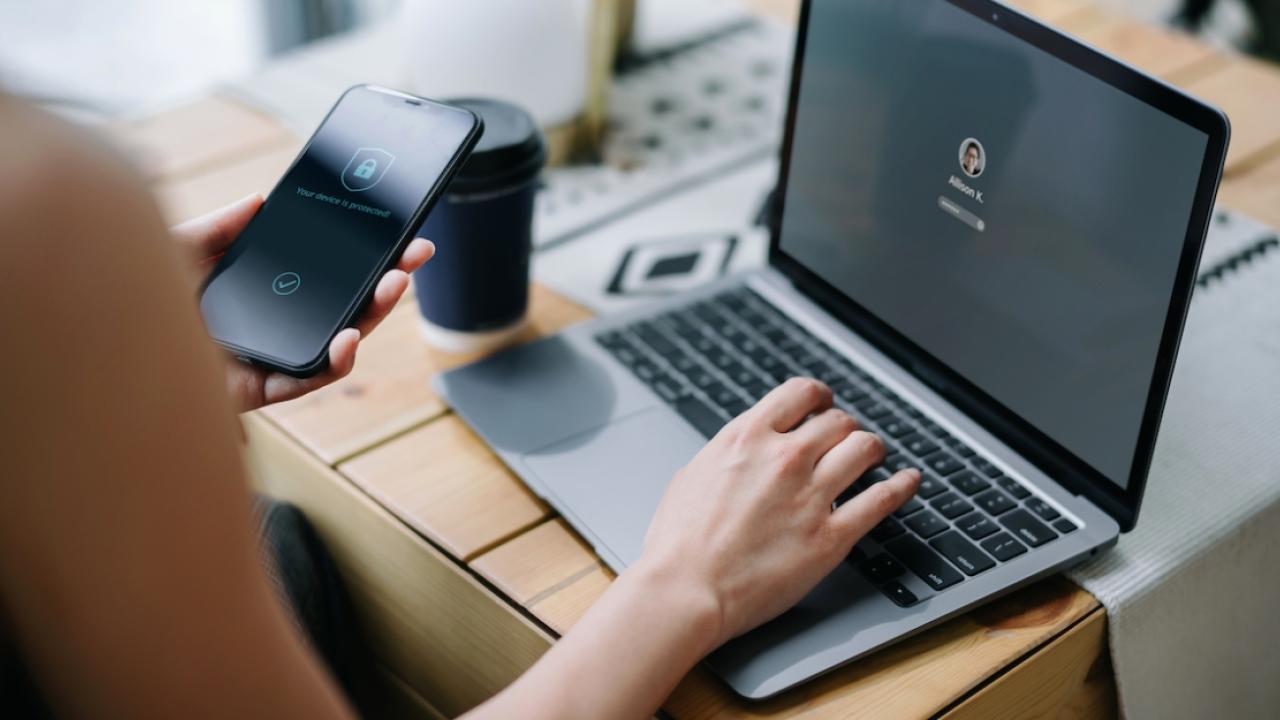 Person working on laptop and phone
