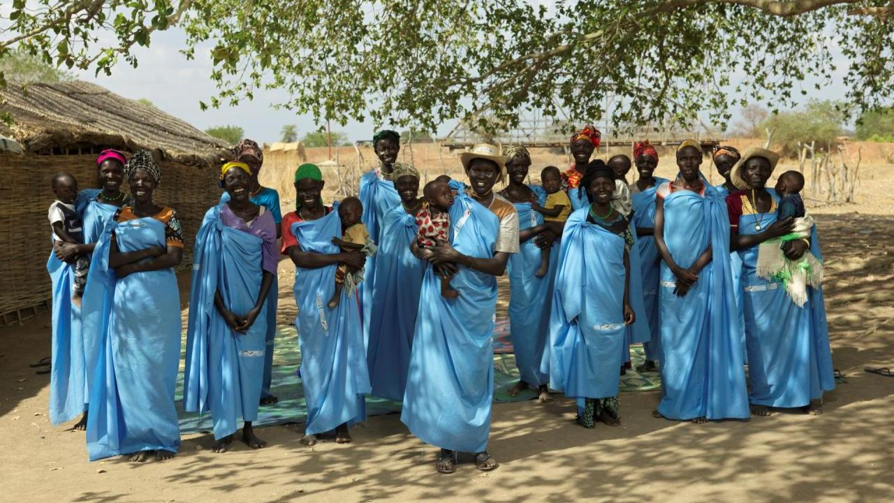 Women wearing blue smile for a photo. 