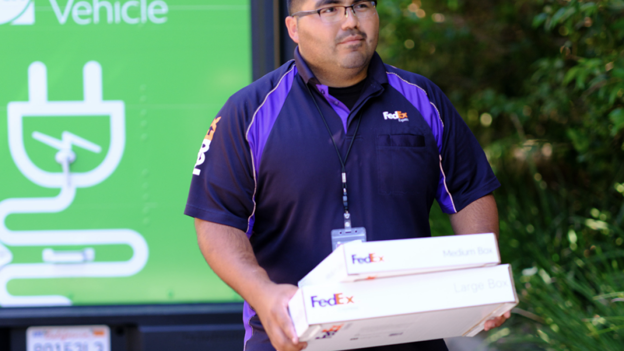 FedEx employee carrying 2 delivery boxes