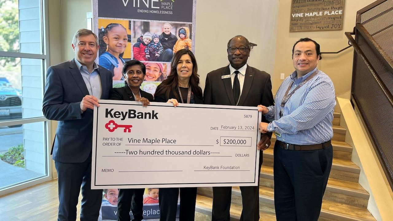 Representatives from Pine Maple Place and KeyBank shown with a $200,000 grant check.