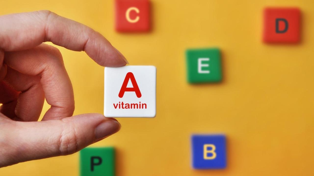 person holding up a block reading "A vitamin"