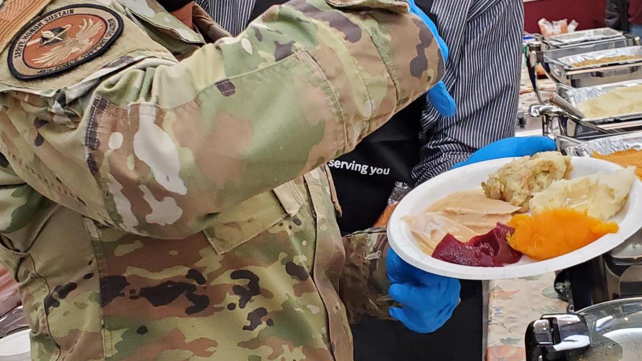 two volunteers holding plate of food 