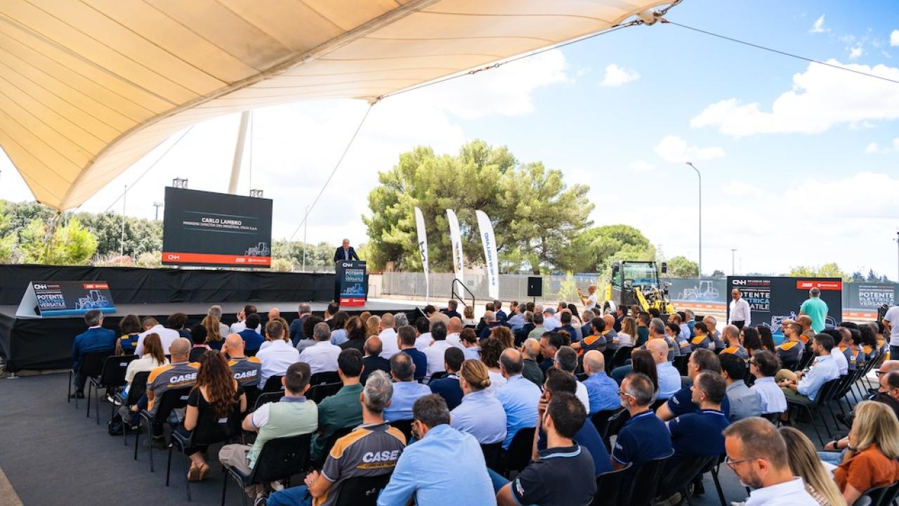 Large group sitting in front of stage in outdoor venue