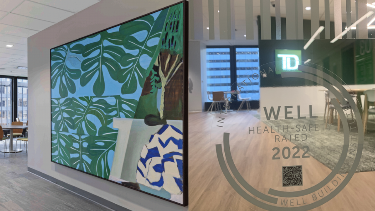 Interior walls of a TD Bank location, the WELL seal emblem on a glass wall