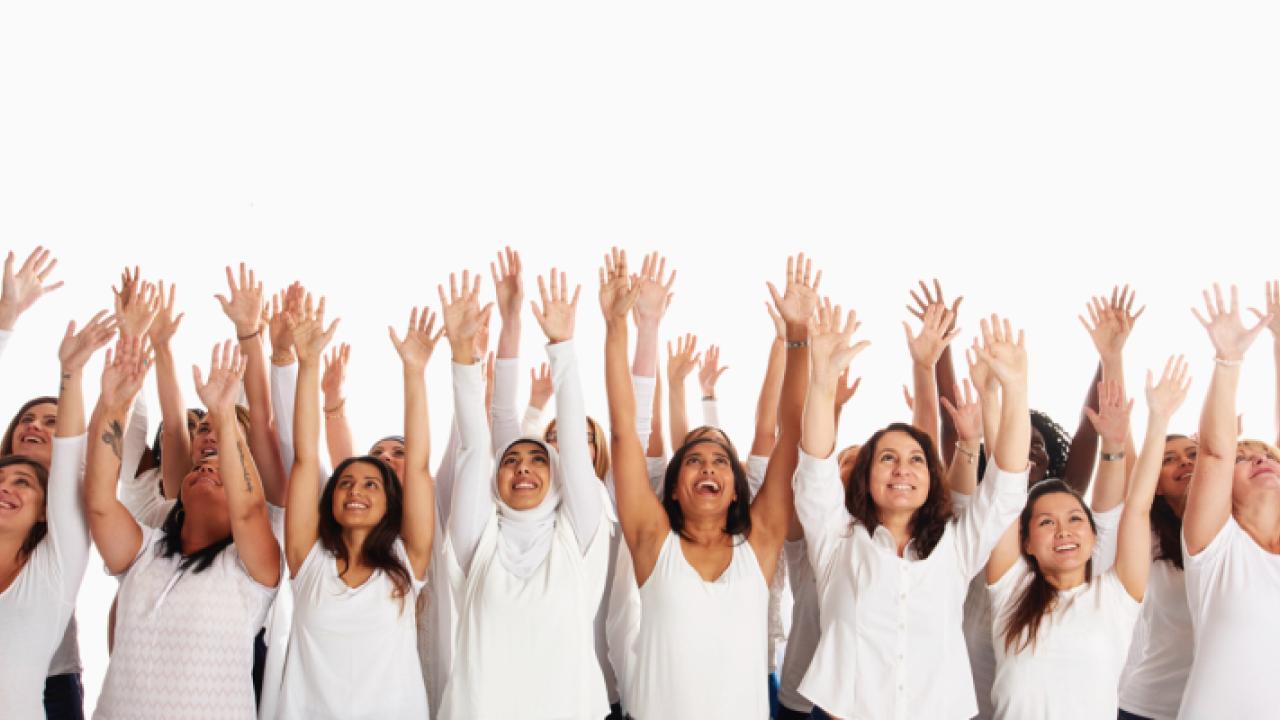 group of people all wearing white shirts, arms raised up