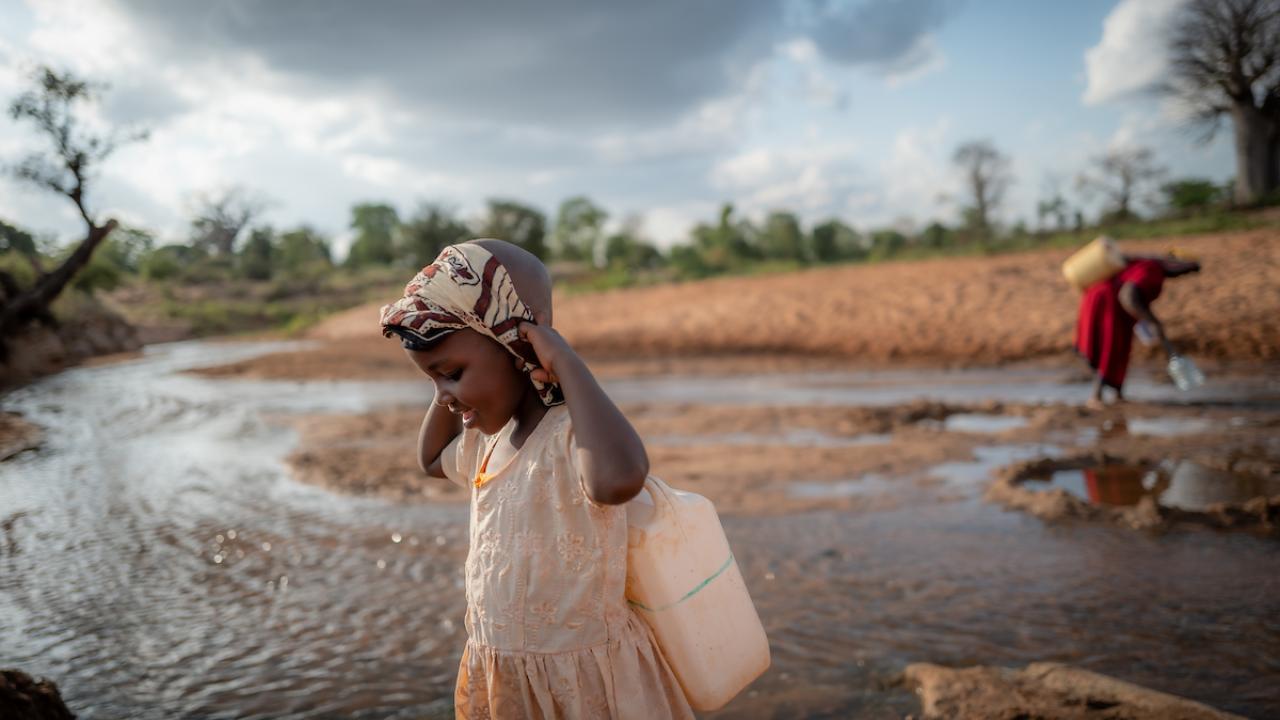 Celestine and her grandmother carrying water