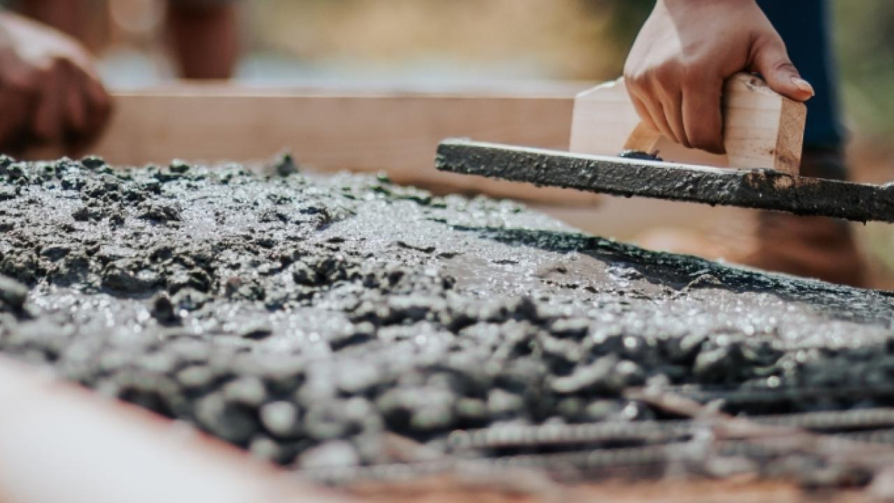 Close up of concrete being spread through rebar