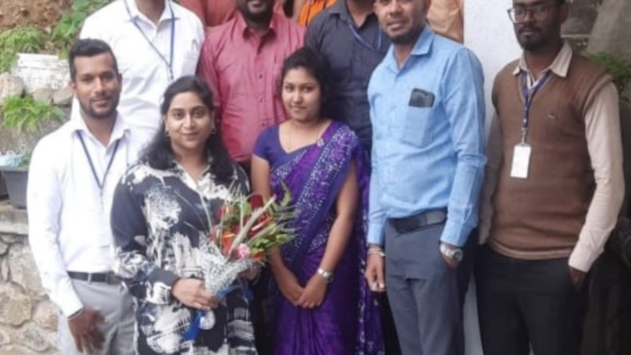 A group of people, one with a bouquet of flowers.