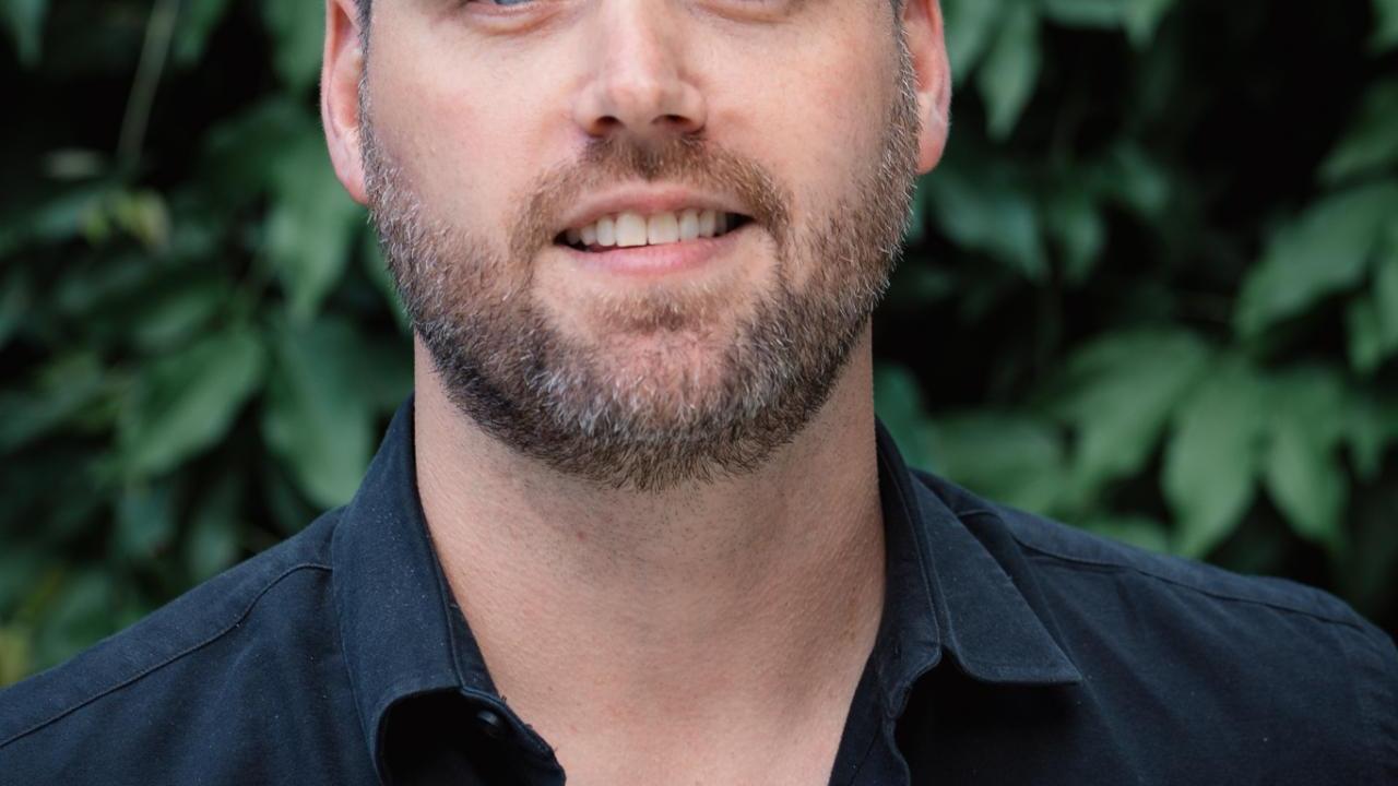 Headshot of Matthew Wemple against a background of leaves