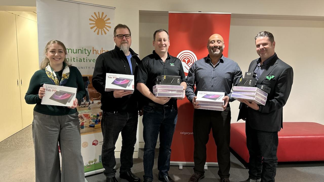 Team members at Wesco holding the tablets that are being donated to United Way of Calgary and Area.