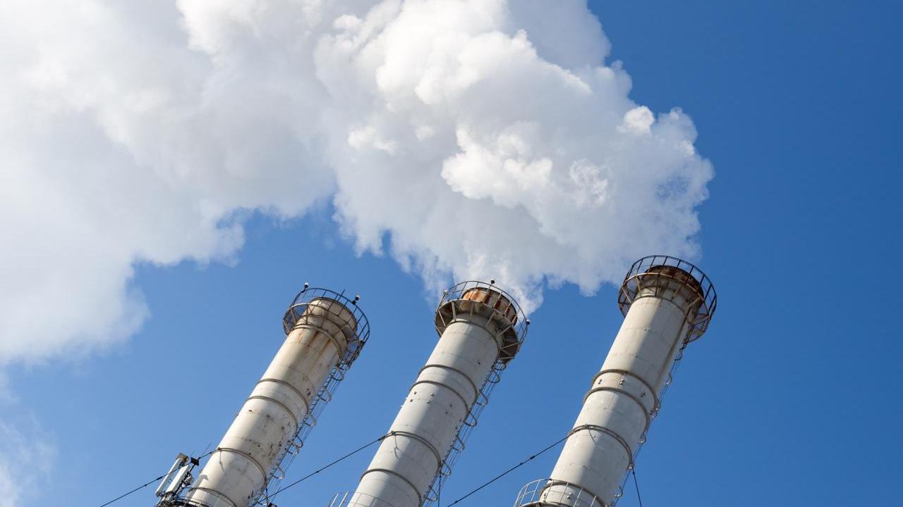 Smoking pipes making clouds against blue sky background