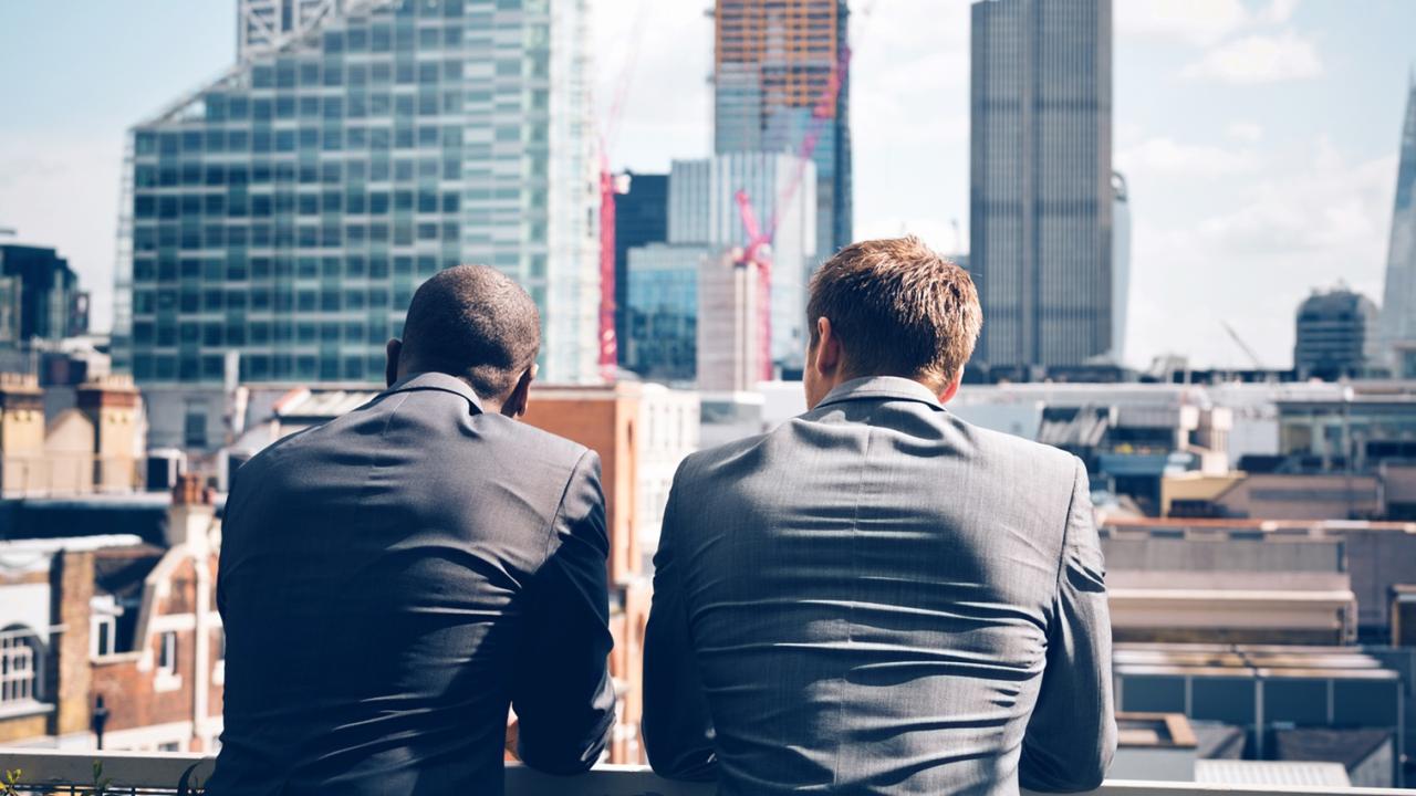 Two businessmen looking at skyline