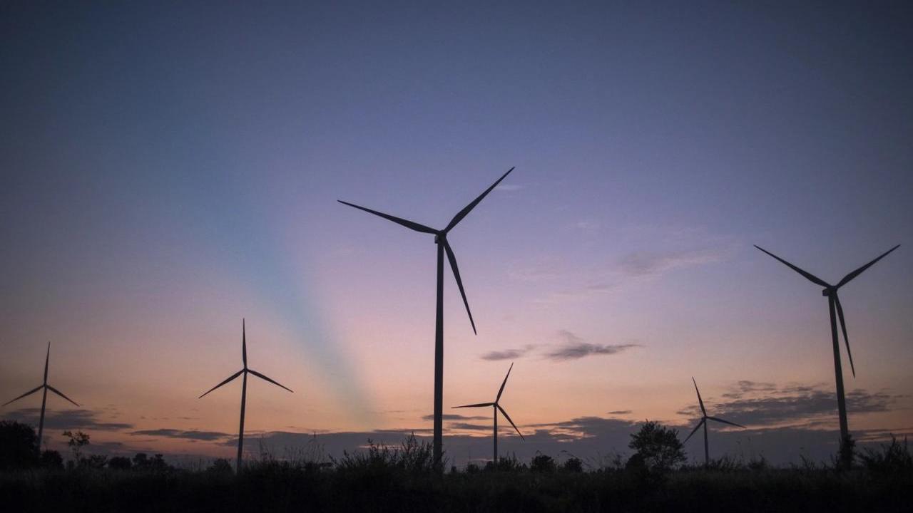 sunset behind wind turbines 