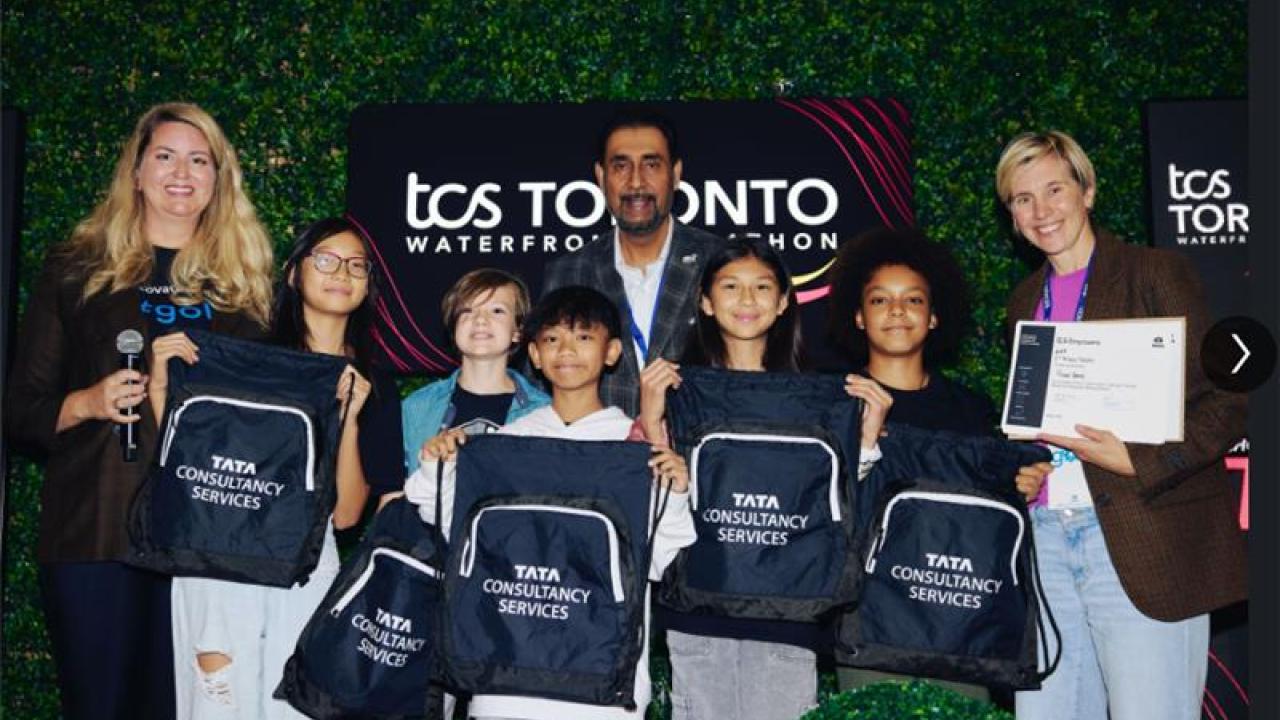 Students holding drawstring Tata Consultancy Services bags