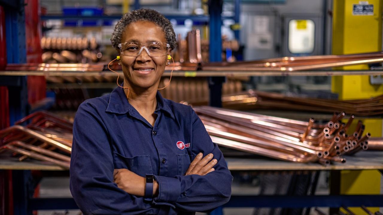 Woman with her arms crossed in a factory