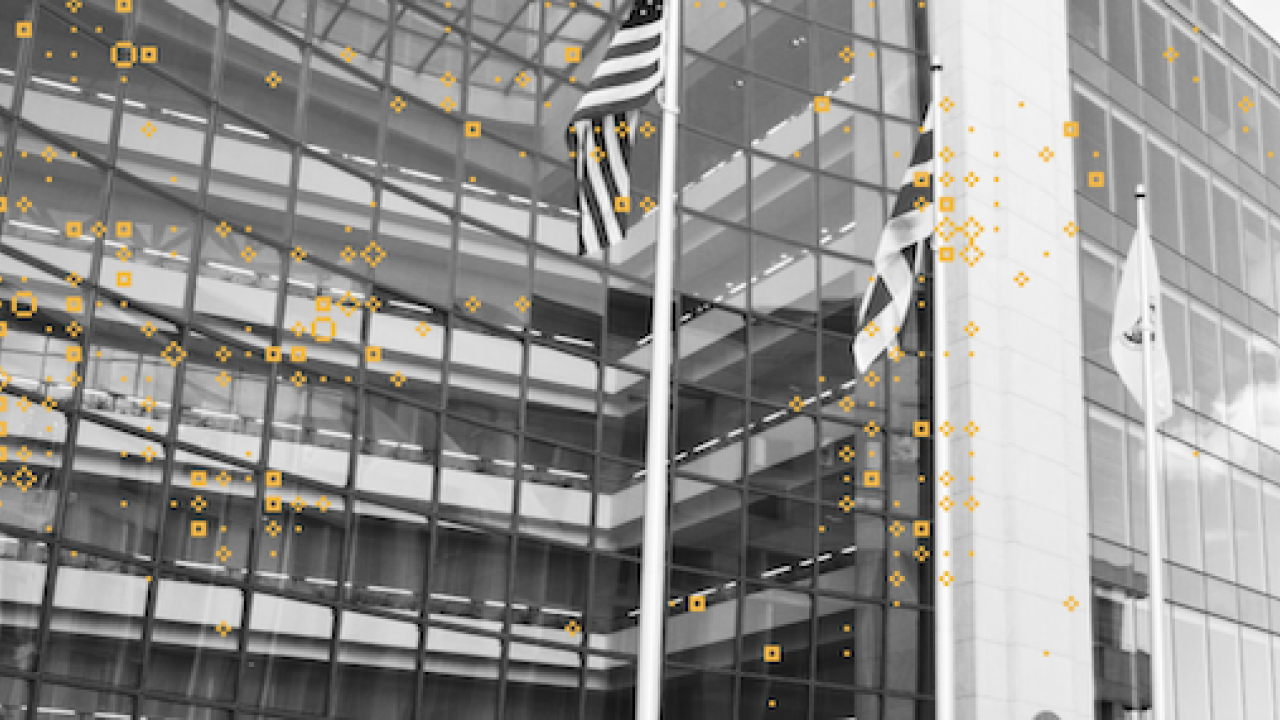 Outside of office building with American flag flying.