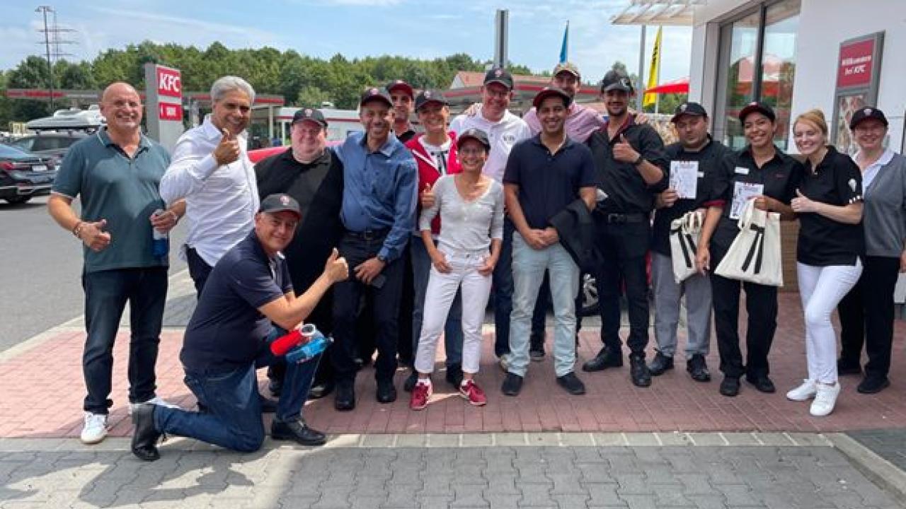 A group photo taken outside of a KFC restaurant 