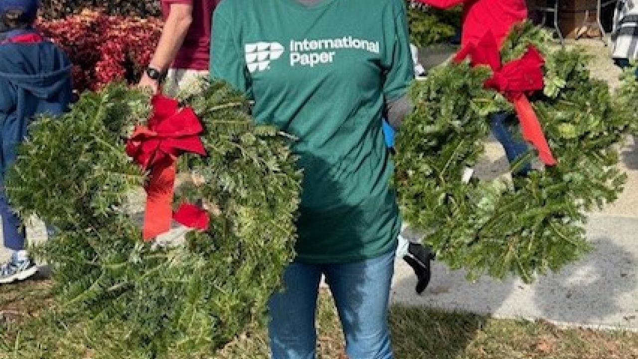 person holding up wreaths