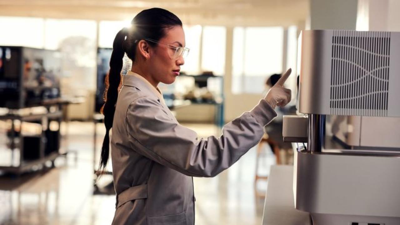 Female clinician operating an Illumina sequencer.