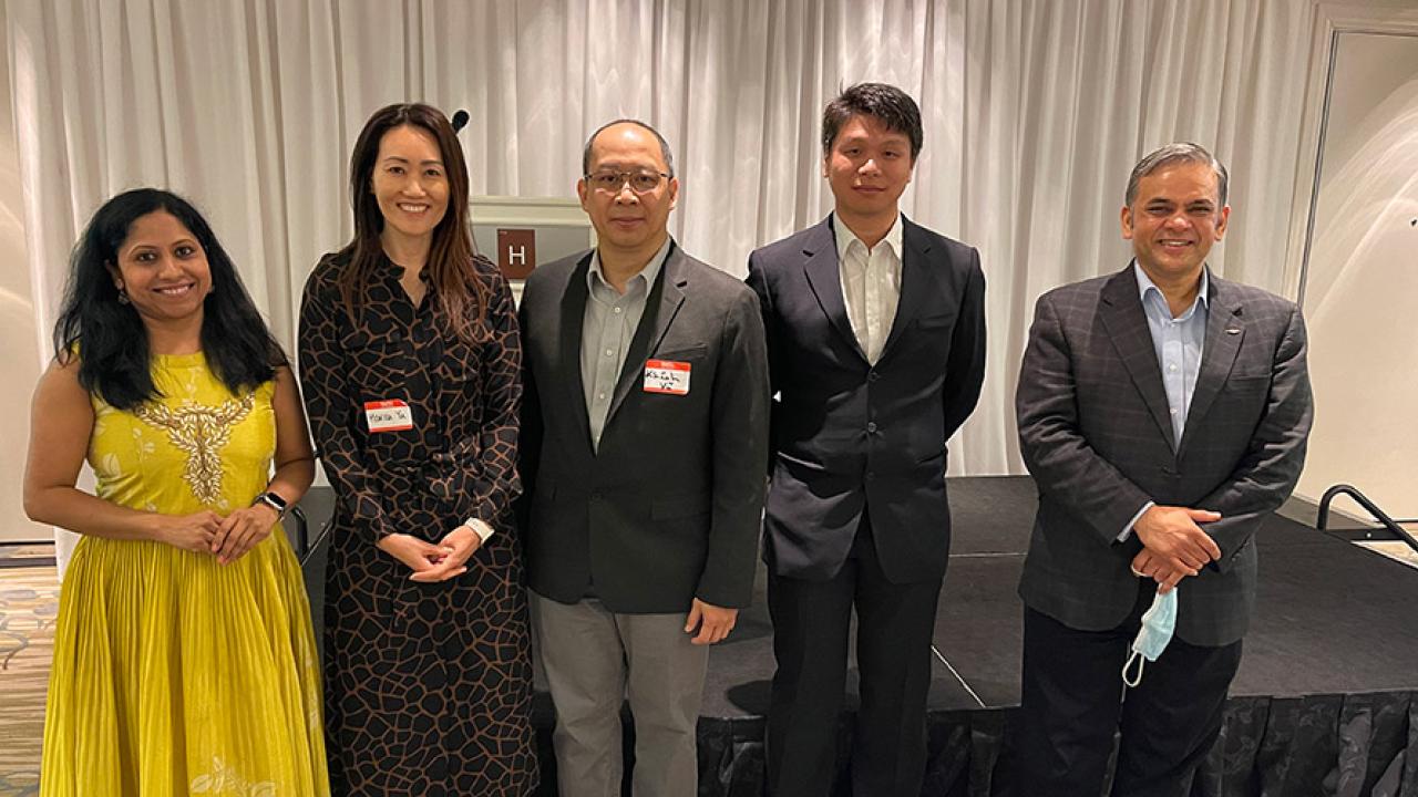 5 AAPI Dow employees, wearing suits and dresses, standing in a row