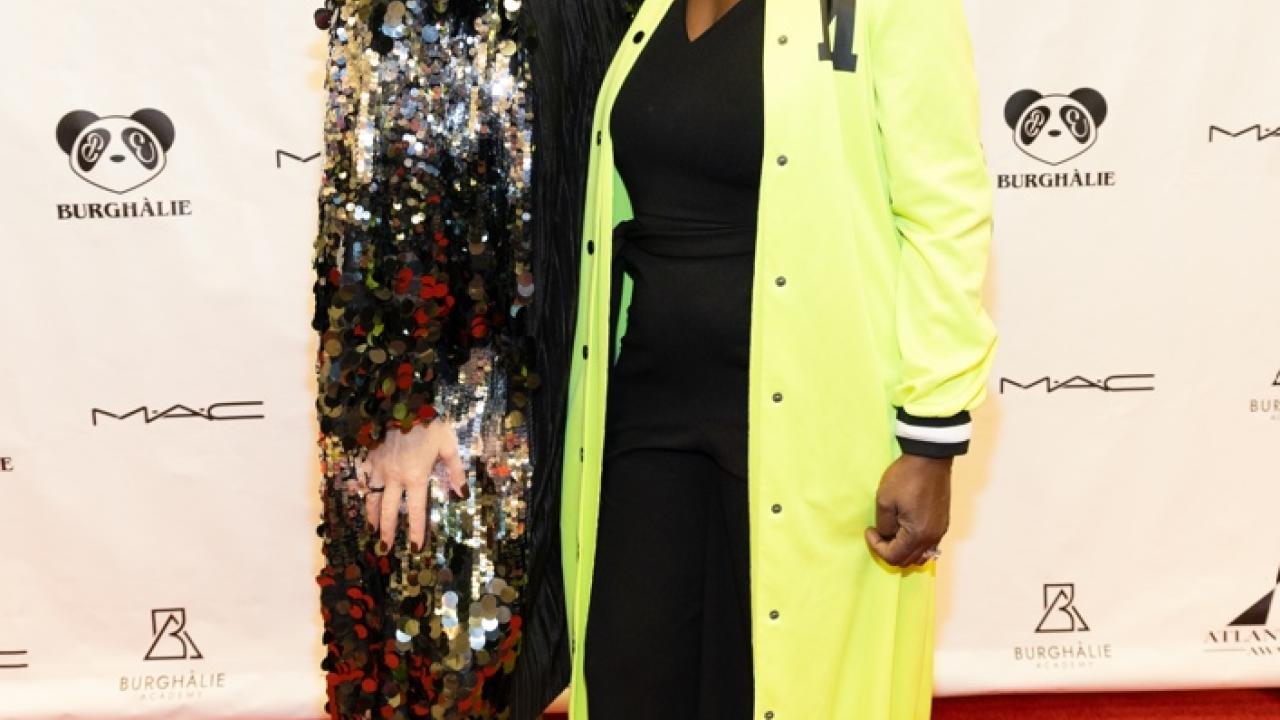 Two smiling people on a red carpet at the gala.