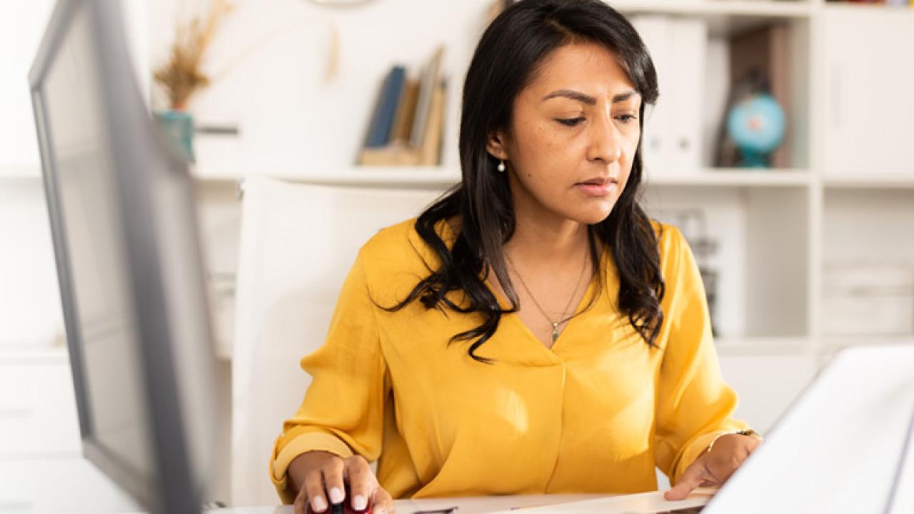 Female worker sitting behind a laptop.
