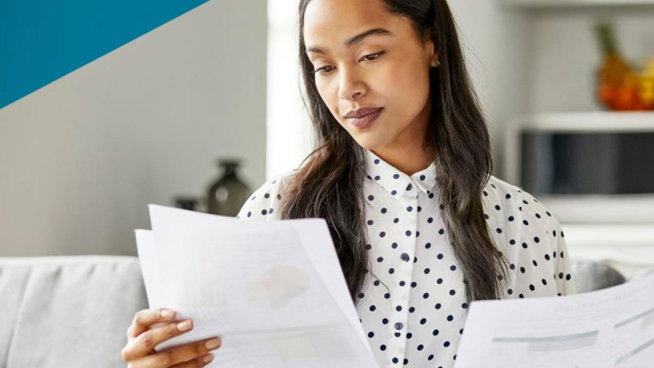 Aflac: Real facts about the No Surprises Act. Woman sitting on a couch reading paperwork.