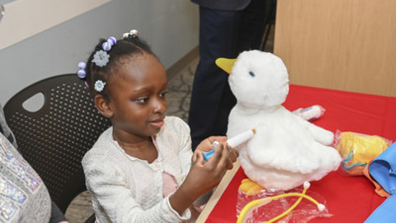 Young black female patient playing with My Special Aflac Duck.